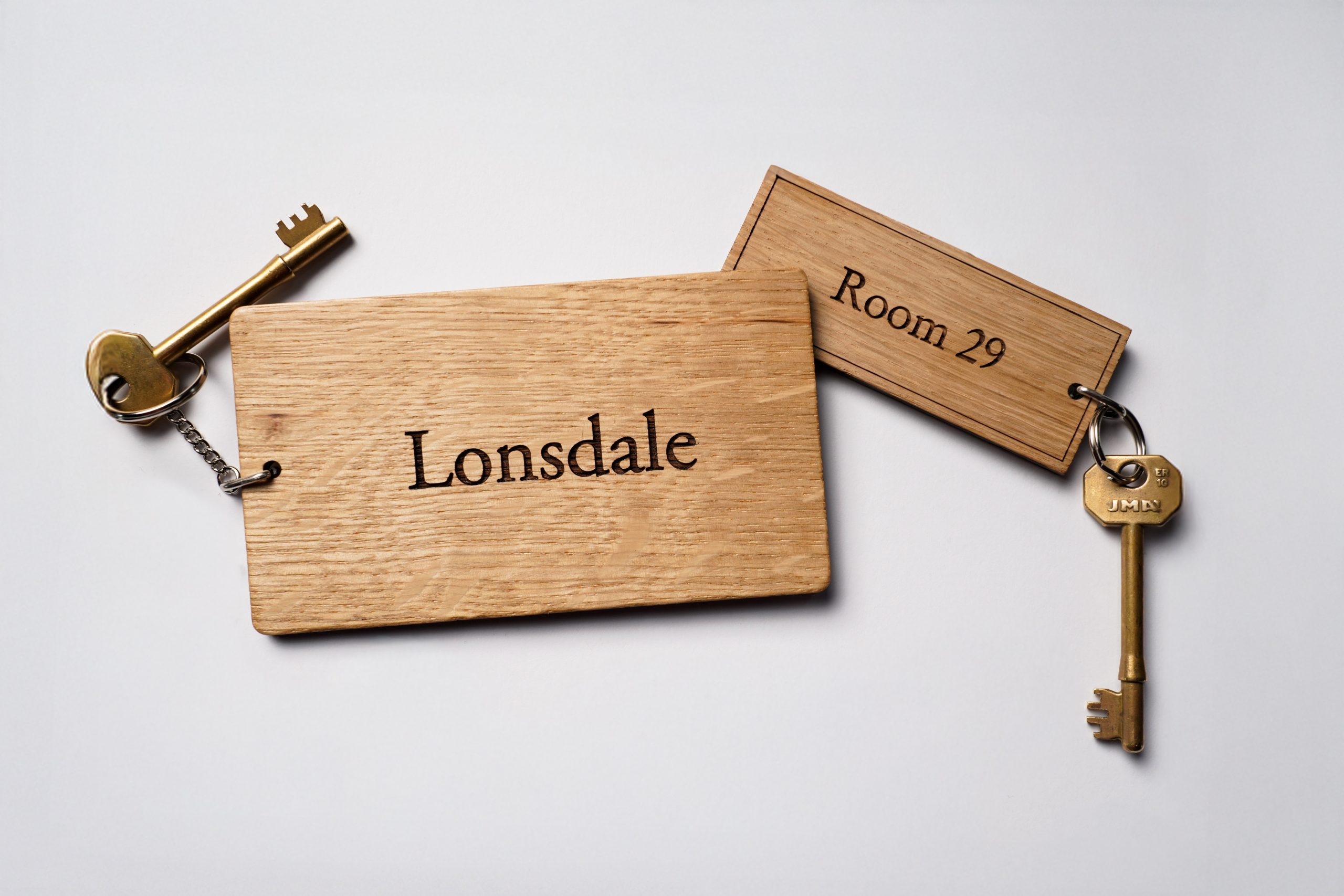 Two oak wood key rings engraved with Lonsdale and Room 29.